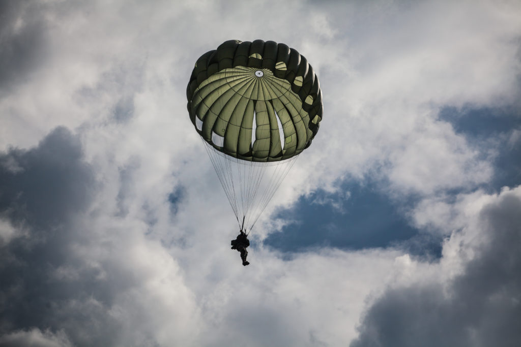 Military parachutist in the war cloudy sky